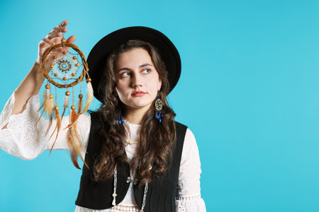 Woman with beautiful dream catcher on light blue background.の写真素材