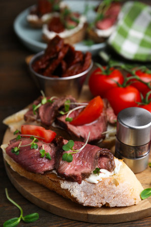 Delicious bruschettas with roast beef served on wooden table, closeupの写真素材