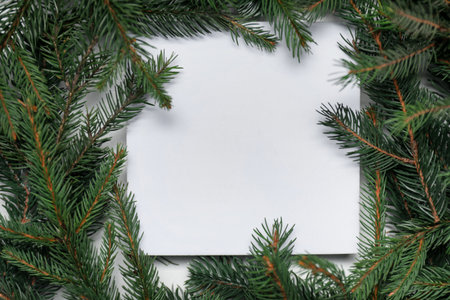 Christmas tree. Frame of spruce branches and blank card, flat lay. Space for textの写真素材