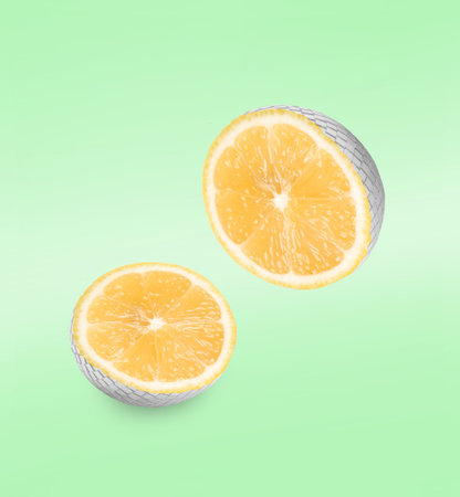 Disco ball with orange inside. Halves in air on green gradient backgroundの写真素材