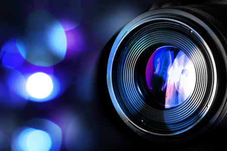 Camera lens against blurred lights, bokeh effect. Banner design