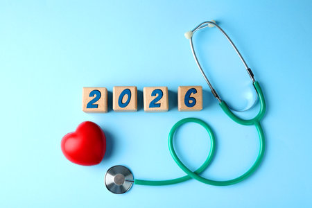 Cubes with numbers, heart and stethoscope on light blue background, top viewの写真素材