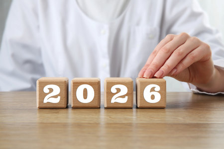 New 2026 year. Doctor putting cube with number 6 on table, closeup