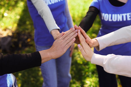 Group of volunteers joining hands outdoors, closeupの写真素材