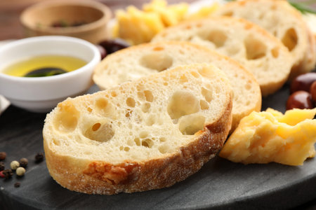 Pieces of fresh ciabatta, peppercorns and cheese on table, closeupの写真素材