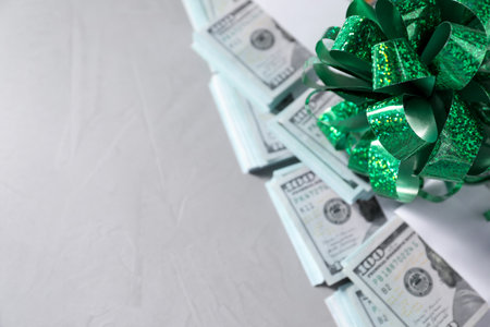 Dollar banknotes with bow on light background, closeup. Space for textの写真素材