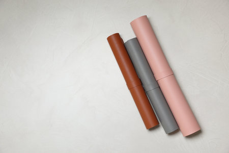 Different rolled computer mats on light gray table, flat lay. Space for textの写真素材