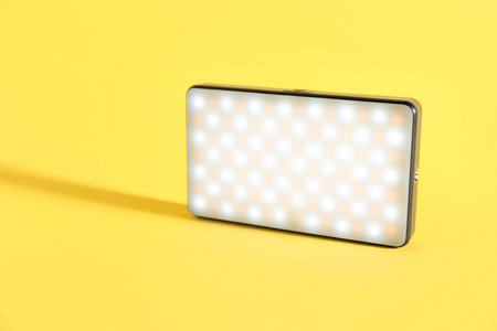 One stylish LED lamp on yellow background. Space for textの写真素材
