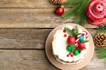 Tasty cake with Christmas decor on wooden table, flat lay. Space for textの写真素材