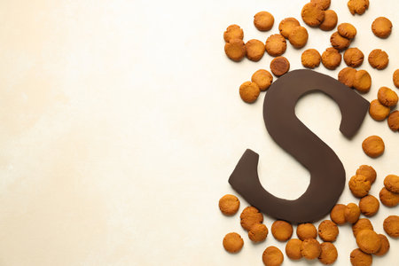 Sinterklaas (Saint Nicholas) Day. Chocolate letter S and kruidnoten cookies on light background, flat lay. Space for textの写真素材