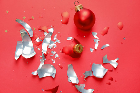 Pieces of broken Christmas ornaments on red background, flat layの写真素材