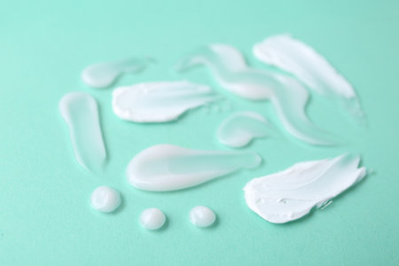 Samples of moisturizing creams on turquoise background, closeupの写真素材