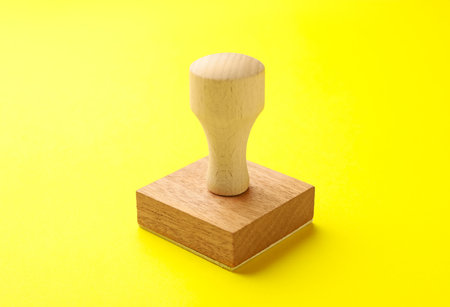 One wooden stamp on yellow background, closeup