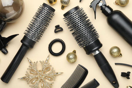 Hairdresser's tools and Christmas decor on beige background, flat lay