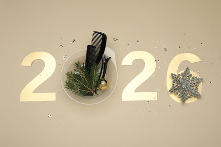 Golden numbers 2026, hairdresser's tools and Christmas decor on beige background, flat lay