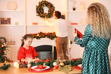 Happy family setting table and decorating room for Christmas, selective focusの写真素材