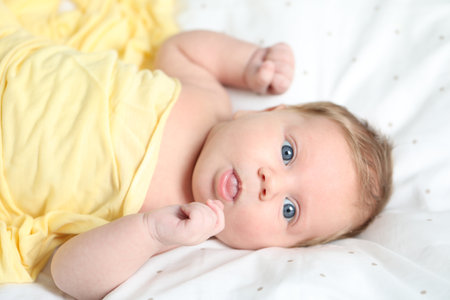 Cute newborn baby in bed at home