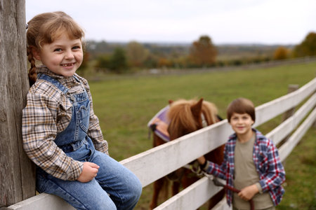 Equine assisted therapy. Cute children with beautiful pony at paddock, selective focus. Lovely domesticated petの写真素材