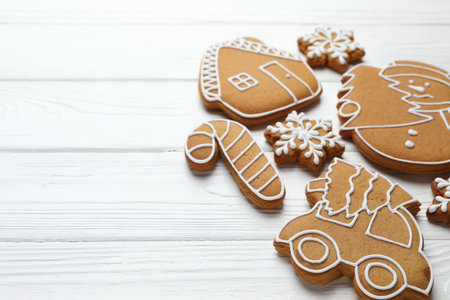 Tasty gingerbread cookies on white wooden table, closeup. Space for textの写真素材