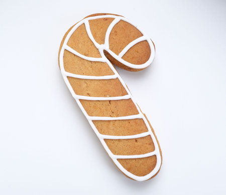 Tasty gingerbread cookie in shape of candy cane isolated on white, top view. Christmas treatの写真素材
