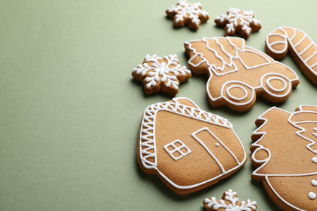 Christmas treat. Tasty gingerbread cookies on green background, closeup. Space for textの写真素材