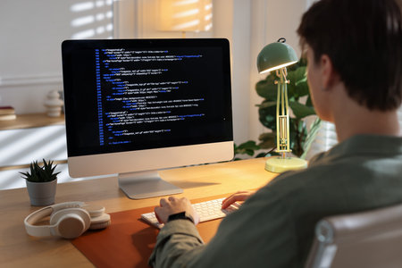 Programmer working on computer at table in officeの写真素材