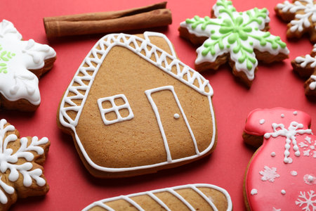 Tasty gingerbread cookies and cinnamon on red background, closeup. Christmas treatの写真素材