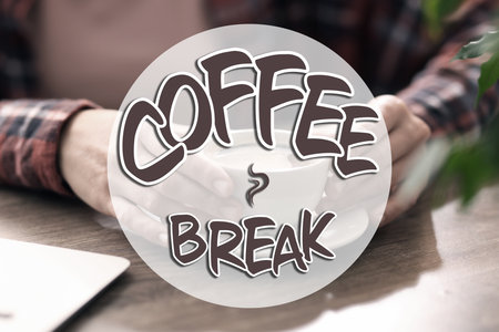 Coffee break time. Woman with cup of hot drink at wooden desk indoors, closeupの写真素材