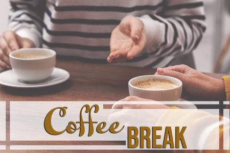 Coffee break time. Women with cups of hot drinks at wooden table indoors, closeupの写真素材