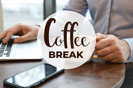 Coffee break time. Office worker with cup of hot drink using laptop at desk, closeupの写真素材