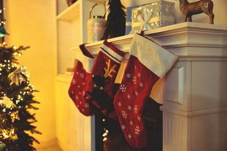 Merry Christmas greeting card. Red socks hanging on fireplace, festive traditionの写真素材