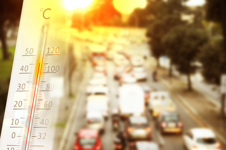 Thermometer showing high temperature, double exposure with road in city during hot dayの写真素材