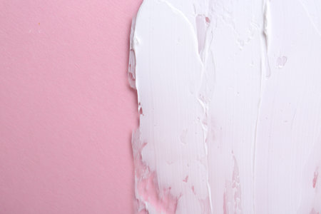 Sample of moisturizing cream on pink background, top view. Space for textの写真素材