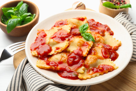 Delicious ravioli with tomato sauce and basil served on white wooden table, closeupの写真素材