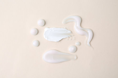 Samples of moisturizing creams on beige background, flat layの写真素材