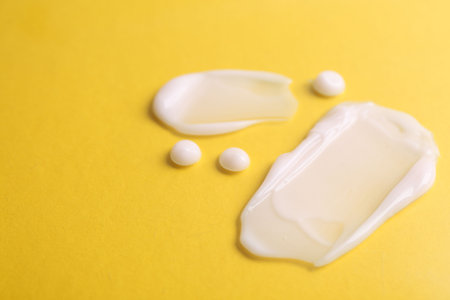Samples of moisturizing creams on yellow background, closeupの写真素材