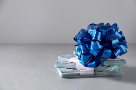Dollar banknotes with bow on light background. Space for textの写真素材
