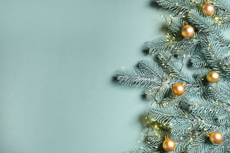 Christmas tree branches with baubles and festive decor on light green background, flat lay. Space for textの写真素材