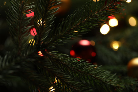 Beautiful spruce tree branches with Christmas ornaments and blurred lights as background, closeup. Bokeh effectの写真素材