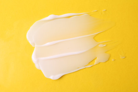 Sample of moisturizing cream on yellow background, top viewの写真素材