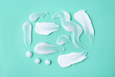 Samples of moisturizing creams on turquoise background, flat layの写真素材