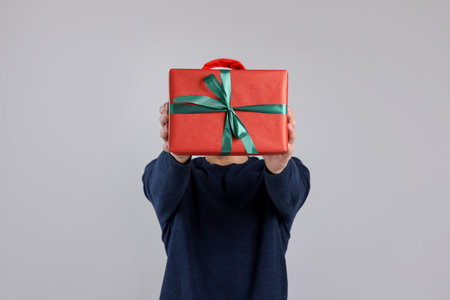 Man with gift box on gray background.