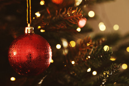 Christmas tree with ball and string lights, closeup. Merry Christmas and Happy Holidays greeting cardの写真素材