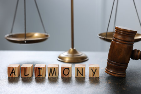 Alimony word made of cubes with letters, judge's gavel and scales of justice on tableの写真素材