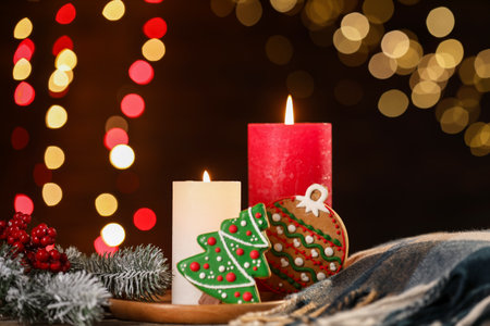 Burning candles and Christmas decor on table against dark background with blurred lights, closeup. Bokeh effectの写真素材