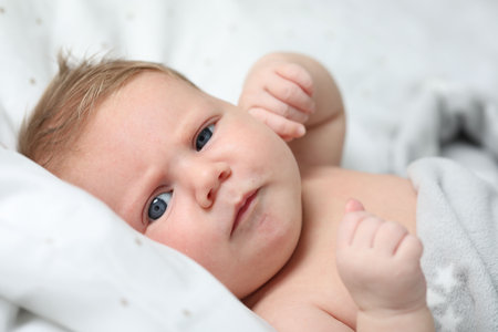 Cute newborn baby in bed at home