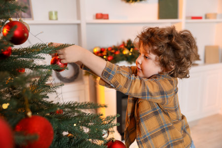 Little boy decorating Christmas tree at homeの写真素材