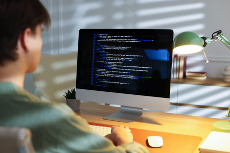 Programmer working on computer at table in officeの写真素材