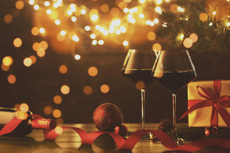 Festive card design with Christmas balls, wine, gift box and bokeh lightsの写真素材