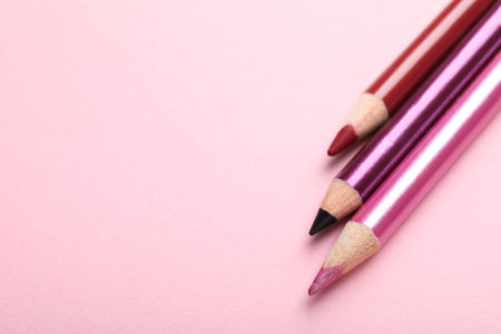 Different eye pencils on pink background, above view. Space for textの写真素材